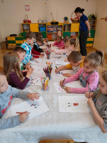 Przedszkolaki kolorują obrazki przedstawiające mrówki