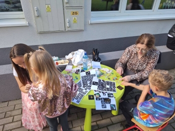 Przedszkolaki podczas wykonywania tatuaży brokatowych na pikniku