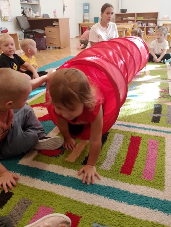 Przedszkolaki z grupy Jeżyki przechodzą przez tor przeszkód.jpeg