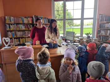 Grupa Żabki w Bibliotece Miejskiej z upominkiem z okazji Tygodnia szczęścia.jpeg